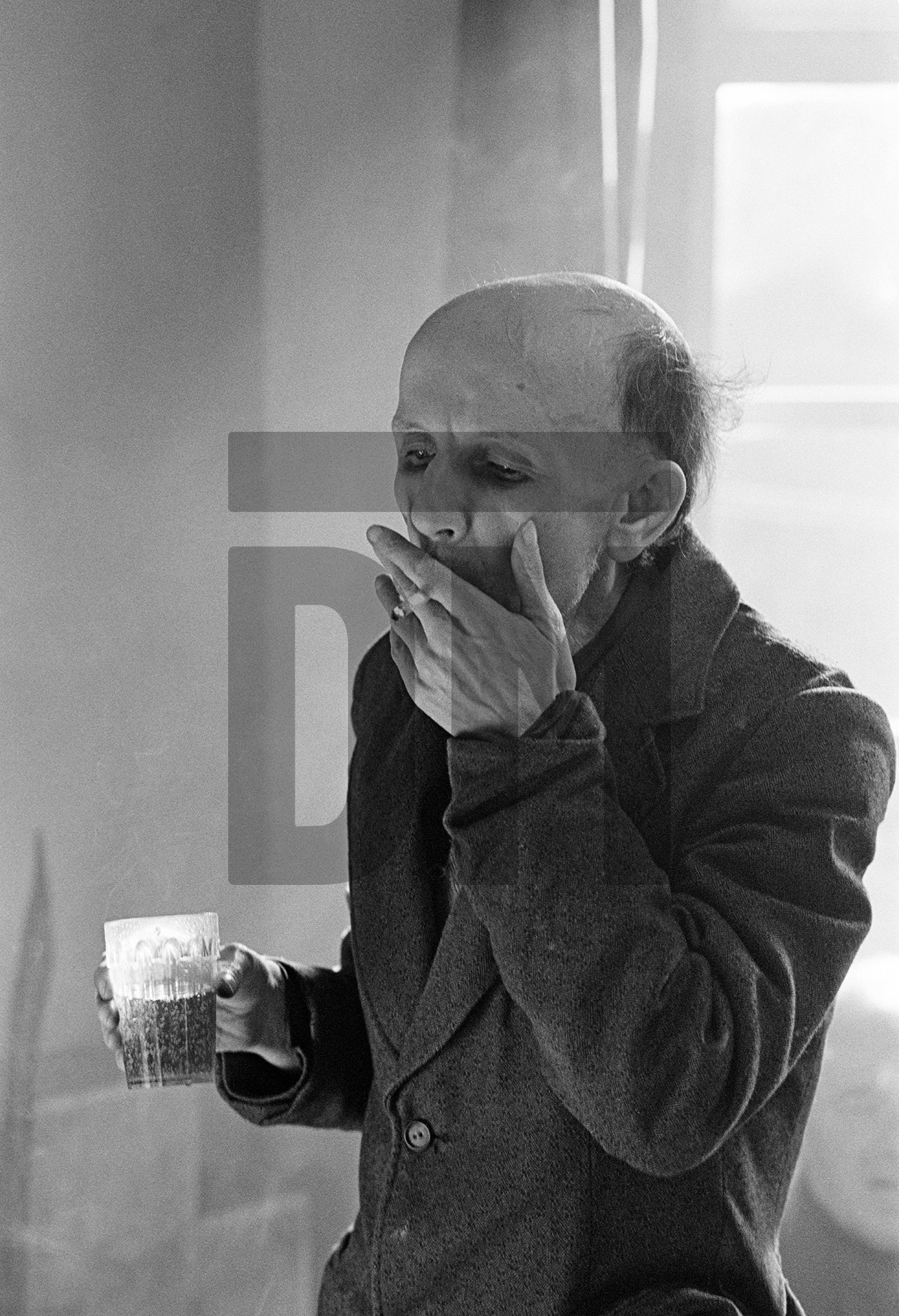 Derek Croley, aged 52 a former bus driver, enjoys a beer (5 tokens) and a cigarette (3 tokens). February 1978 by Daniel Meadows