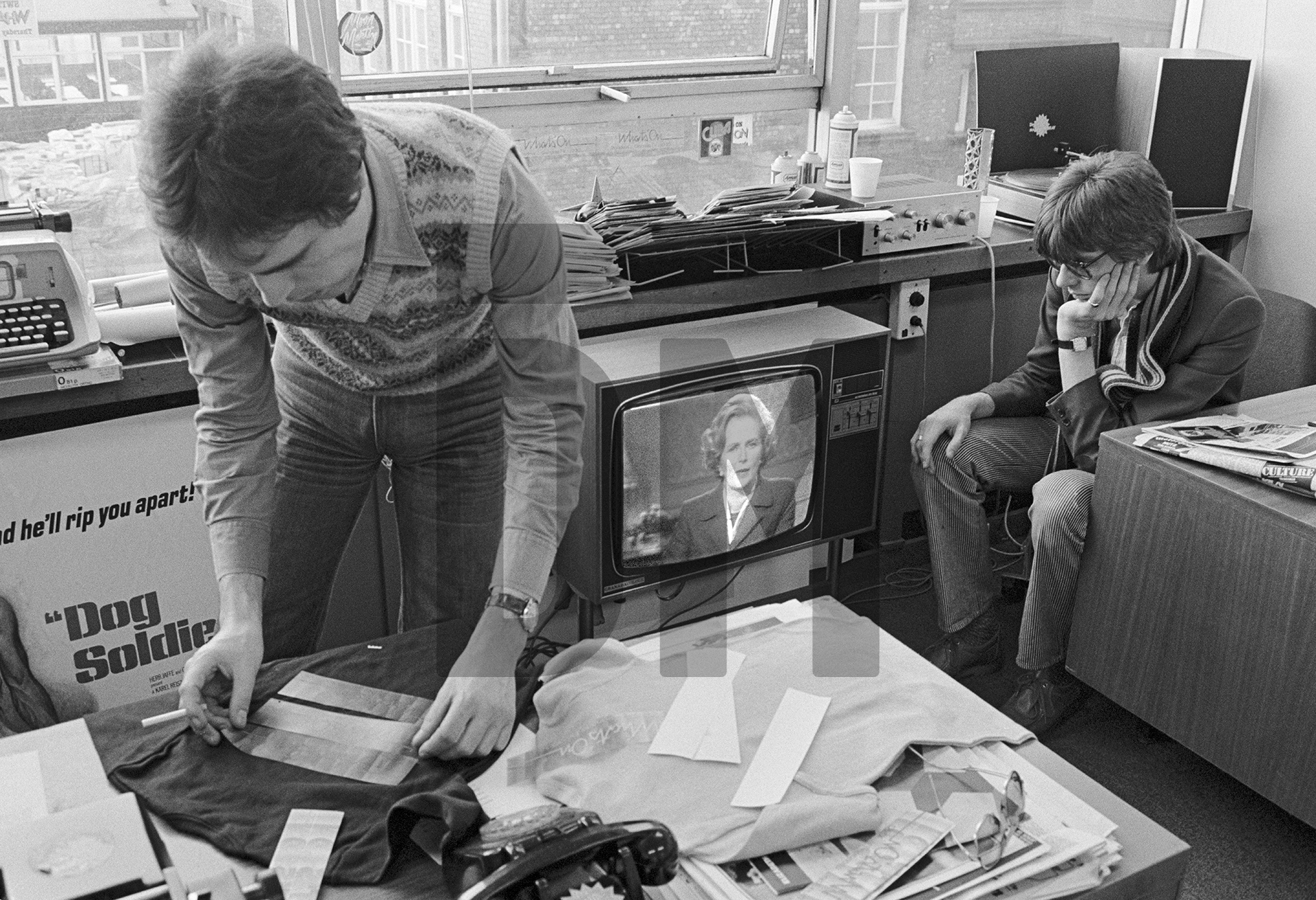 In the ‘What’s On’ office, producer Geoff Moore (left), with director David Liddiment watch Margaret Thatcher on the screen, Granada TV, Quay Street, Manchester. April 1979 by Daniel Meadows
