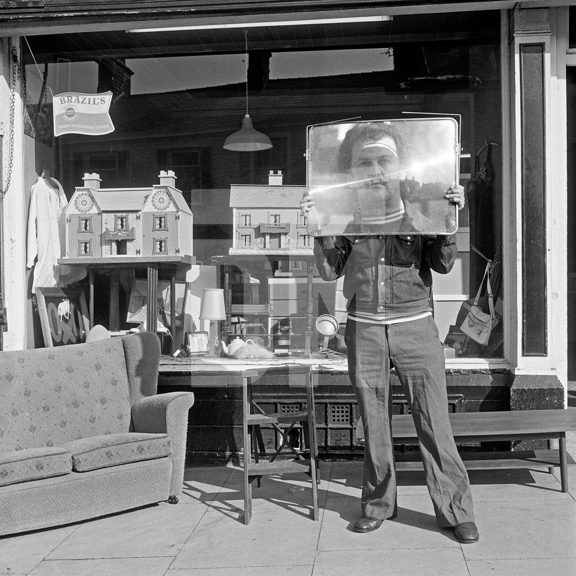 Second-hand goods shop with proprietor, Colne, Lancashire. November 1975 by Daniel Meadows