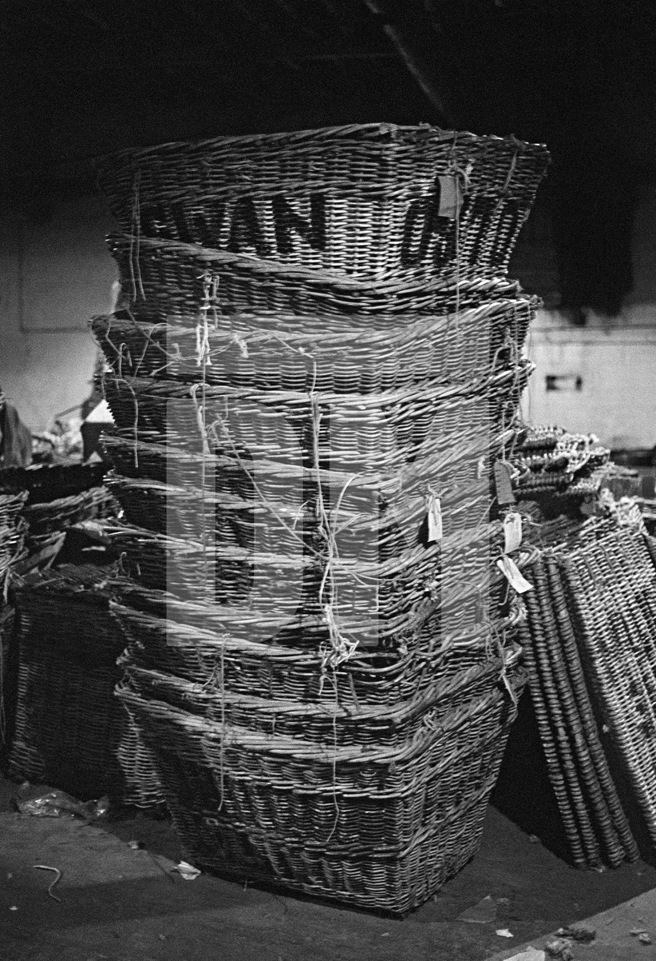In the warehouse, stack of empty yarn skeps. January 1977 by Daniel Meadows