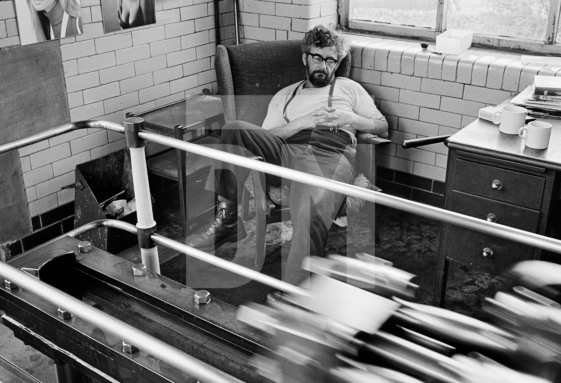 In the engine house. Stanley Graham, mill engineer, sleeping in his armchair beside the low pressure tail slide. May 1976 by Daniel Meadows