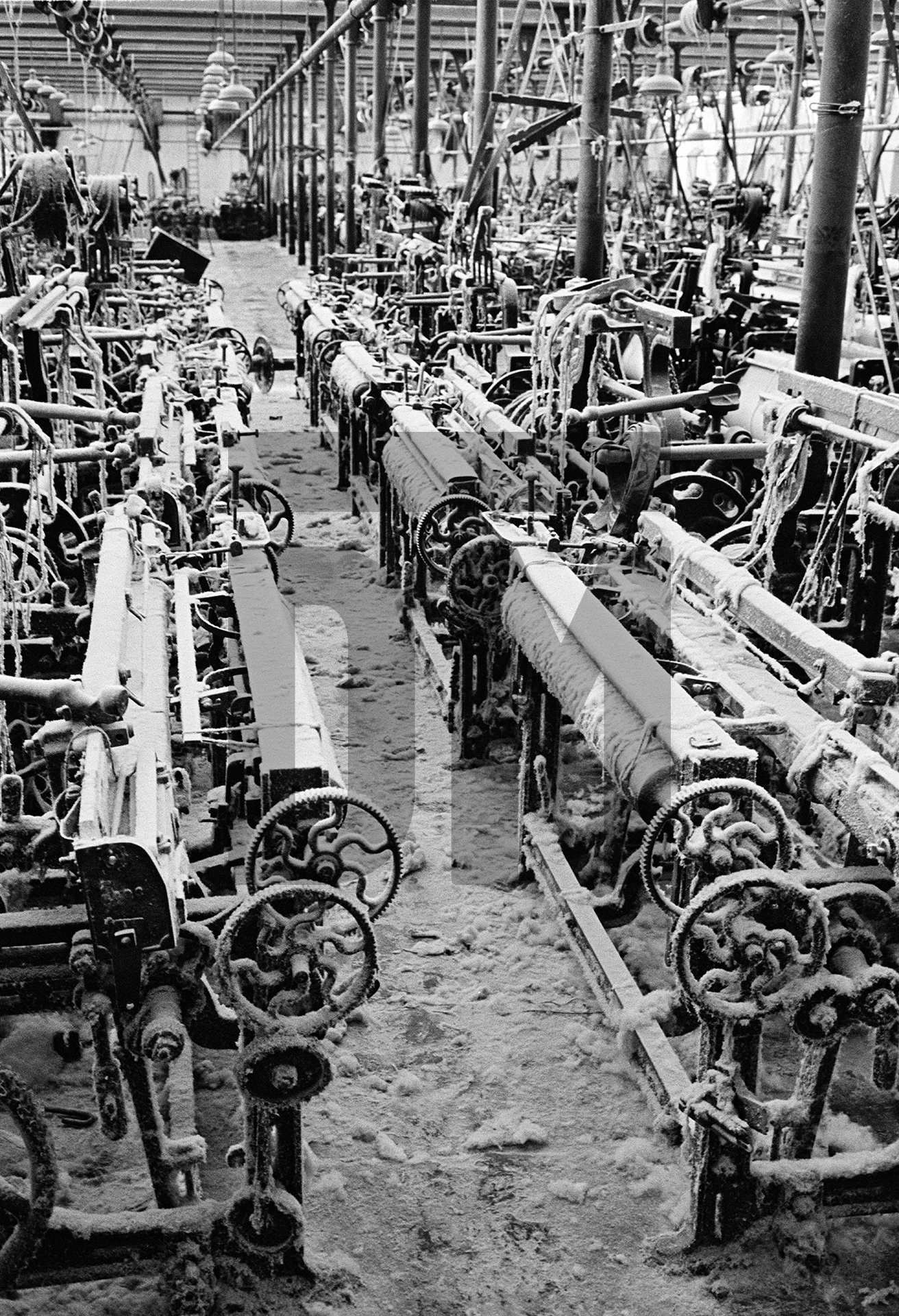 In the weaving shed, empty loom alley. August 1976 by Daniel Meadows