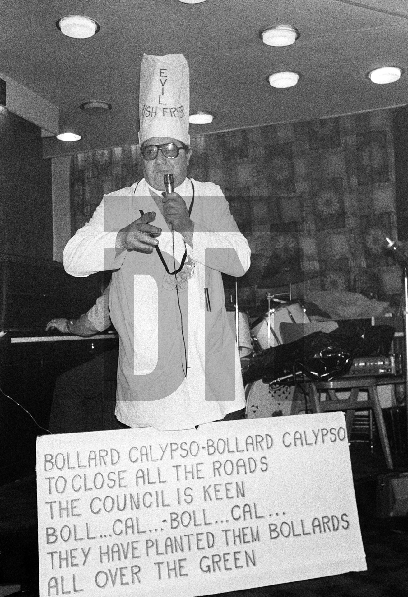 Italo ‘Roy’ Rigali, singing his 'Bollard Calypso' — a protest song against parking restrictions imposed on customers at his fish and chip shop — in a working men's club, Easington Village, Co. Durham. September 1974 by Daniel Meadows