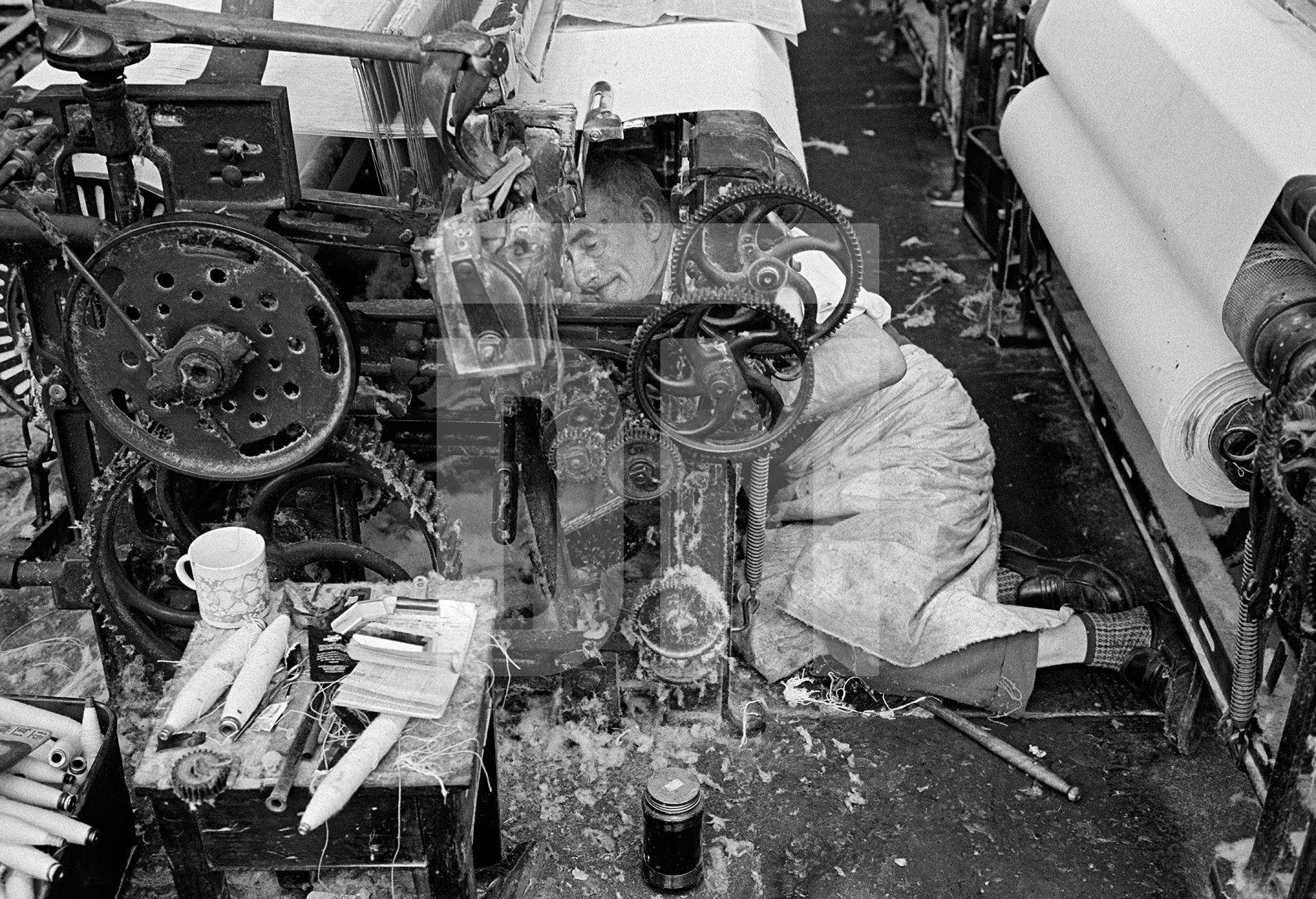 In the weaving shed. Loom sweeper. May 1976 by Daniel Meadows