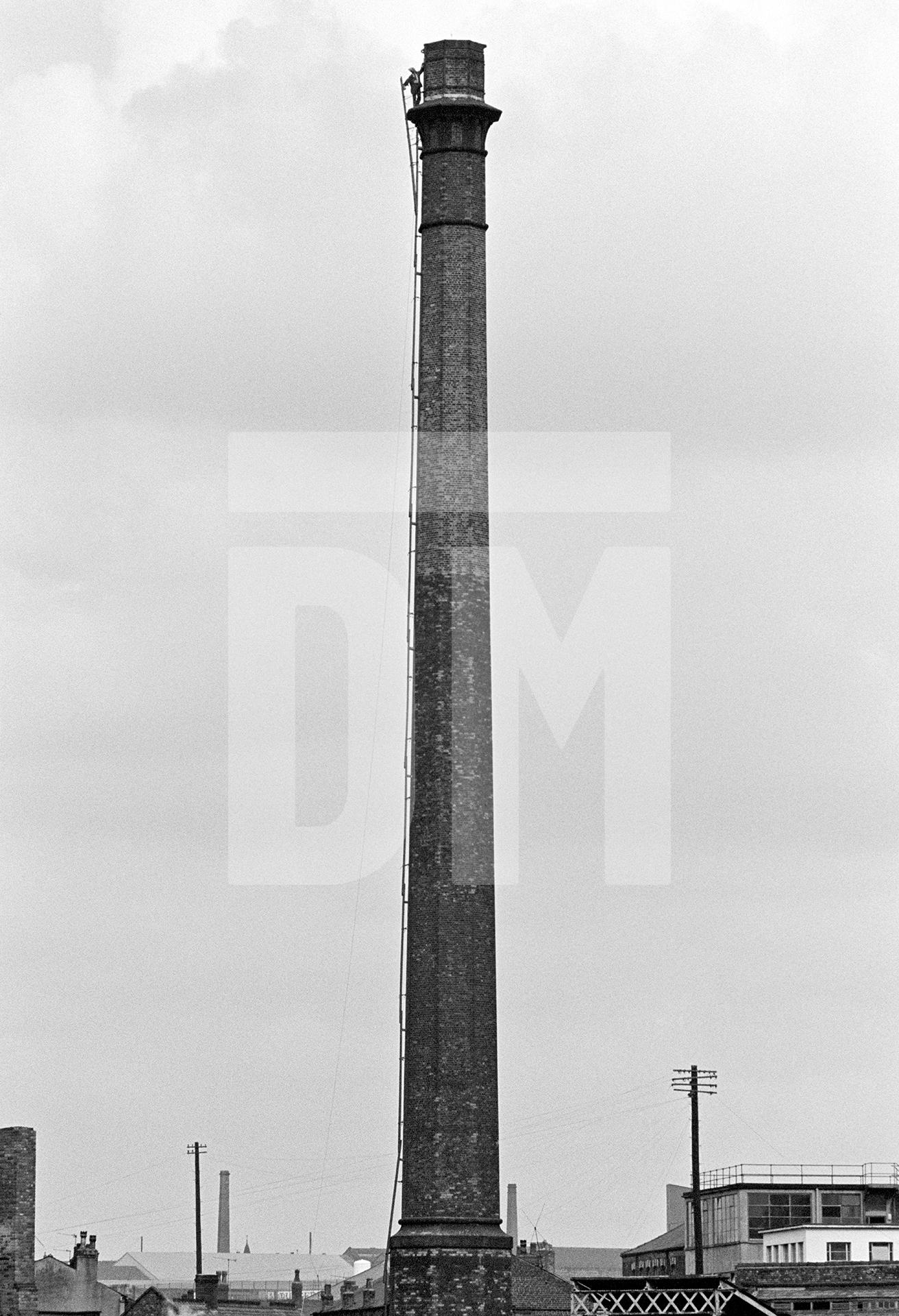 Peter stands on the oversailer while completing laddering prior to demolition. September 1976 by Daniel Meadows