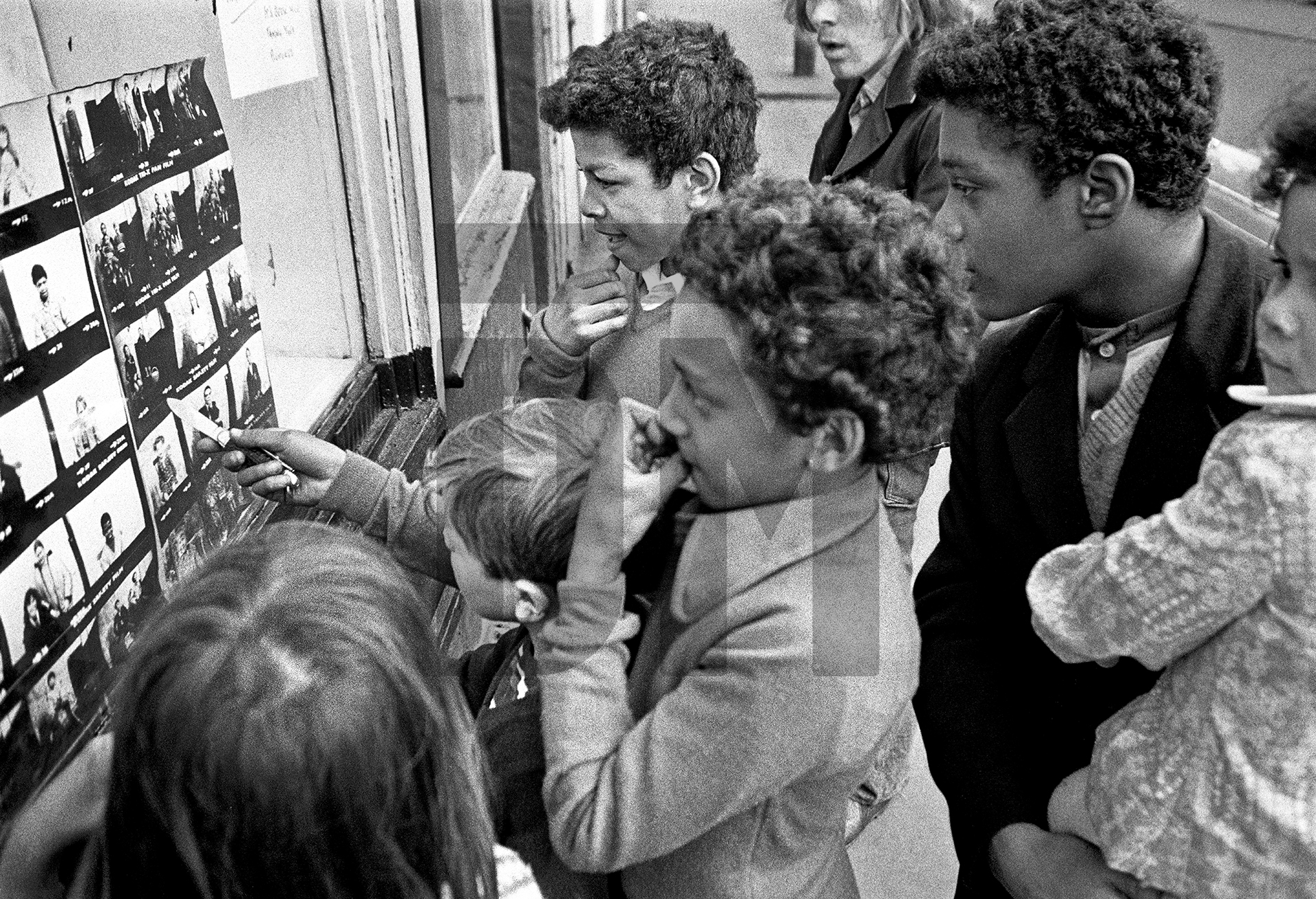 Looking at pictures in the window of The Shop on Greame Street, Moss Side, Manchester. February-April 1972 by Daniel Meadows