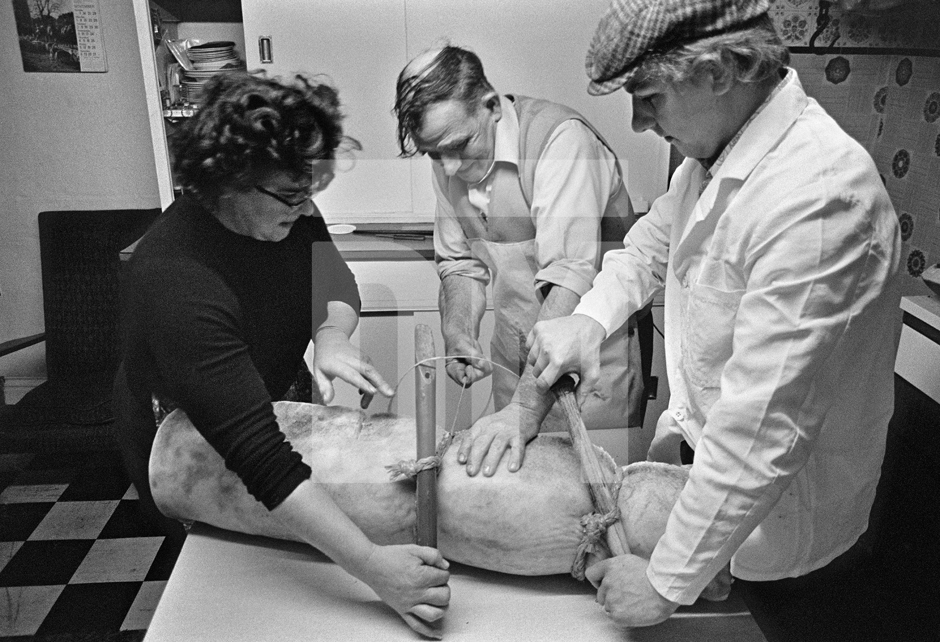 Elsie and Cyril Richardson with Tony Critchley (right) twitch up a bacon roll with twine. North Yorkshire 1976 by Daniel Meadows