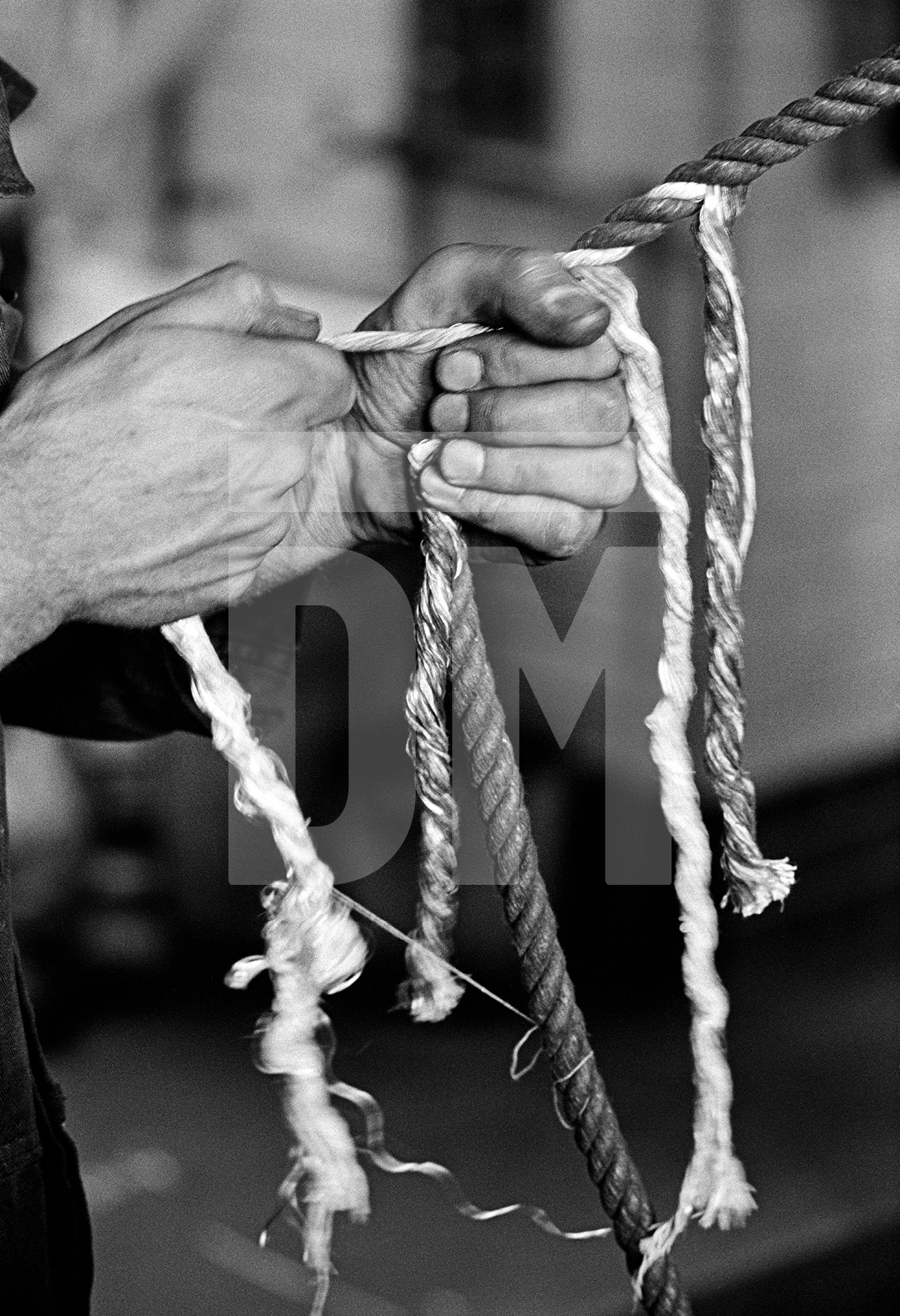 In the engine house. Wakes holiday maintenance. Knotting and splicing governor ropes. July 1976 by Daniel Meadows