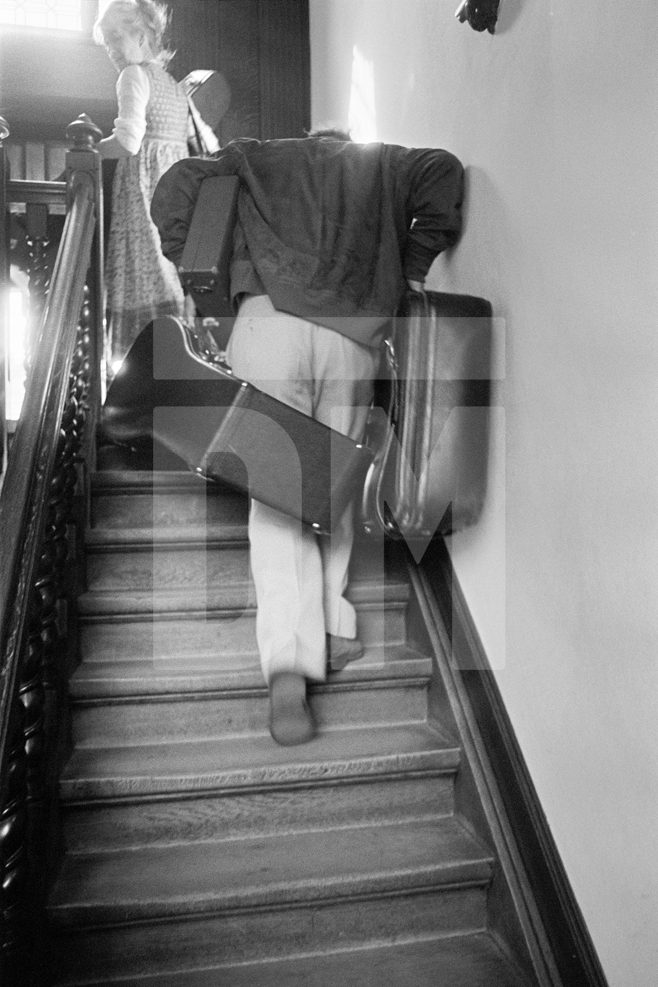 Julian Bream arriving at a hotel, carrying his luggage, Antwerp. September 1981 by Daniel Meadows