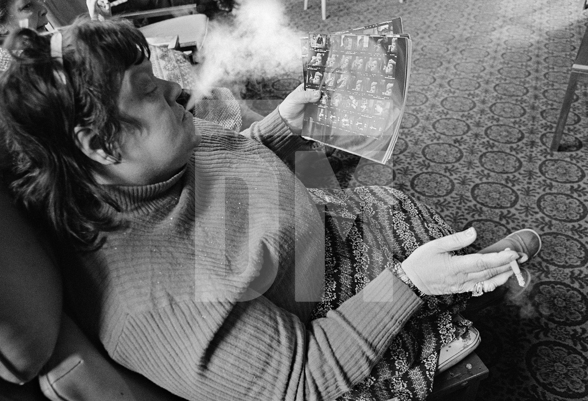 Evelyn Clarke, a former housewife, examines the photographer’s contact sheets. February 1978 by Daniel Meadows