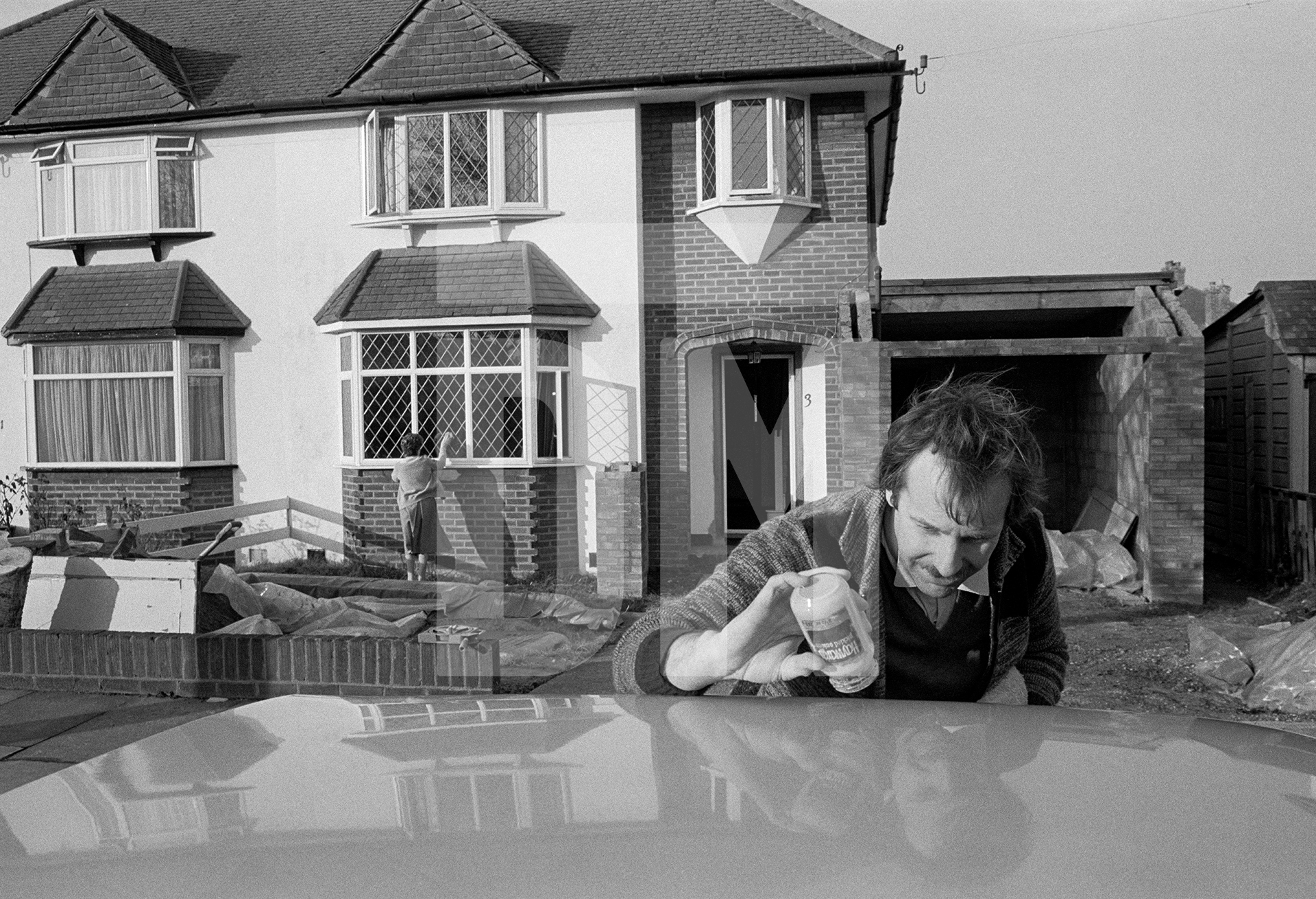 Polishing the car, cleaning windows. Hayes, Kent. February 1985 by Daniel Meadows