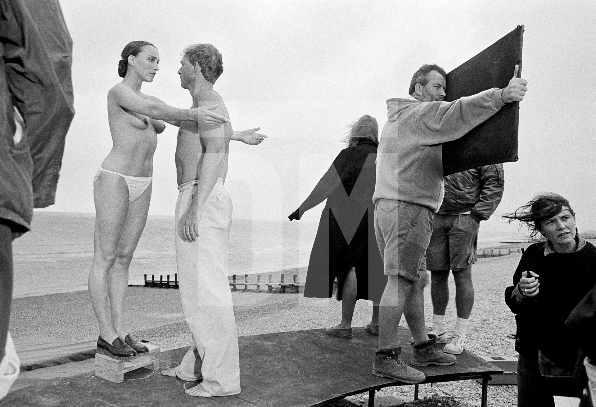 Amanda King [Slava] and Patrick Ryecart [Bohuslav Martinů], setting up the shot on location. Broomhill, East Camber Sands, East Sussex. Ken Russell’s ‘The Mystery of Doctor Martinu’, September 1991 by Daniel Meadows