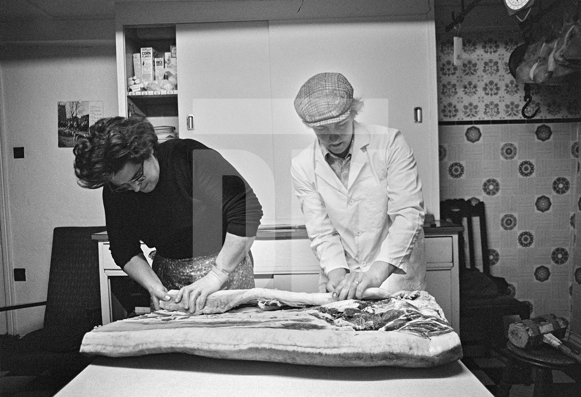 Elsie Richardson and Tony Critchley begin to roll a flitch of bacon. North Yorkshire 1976 by Daniel Meadows