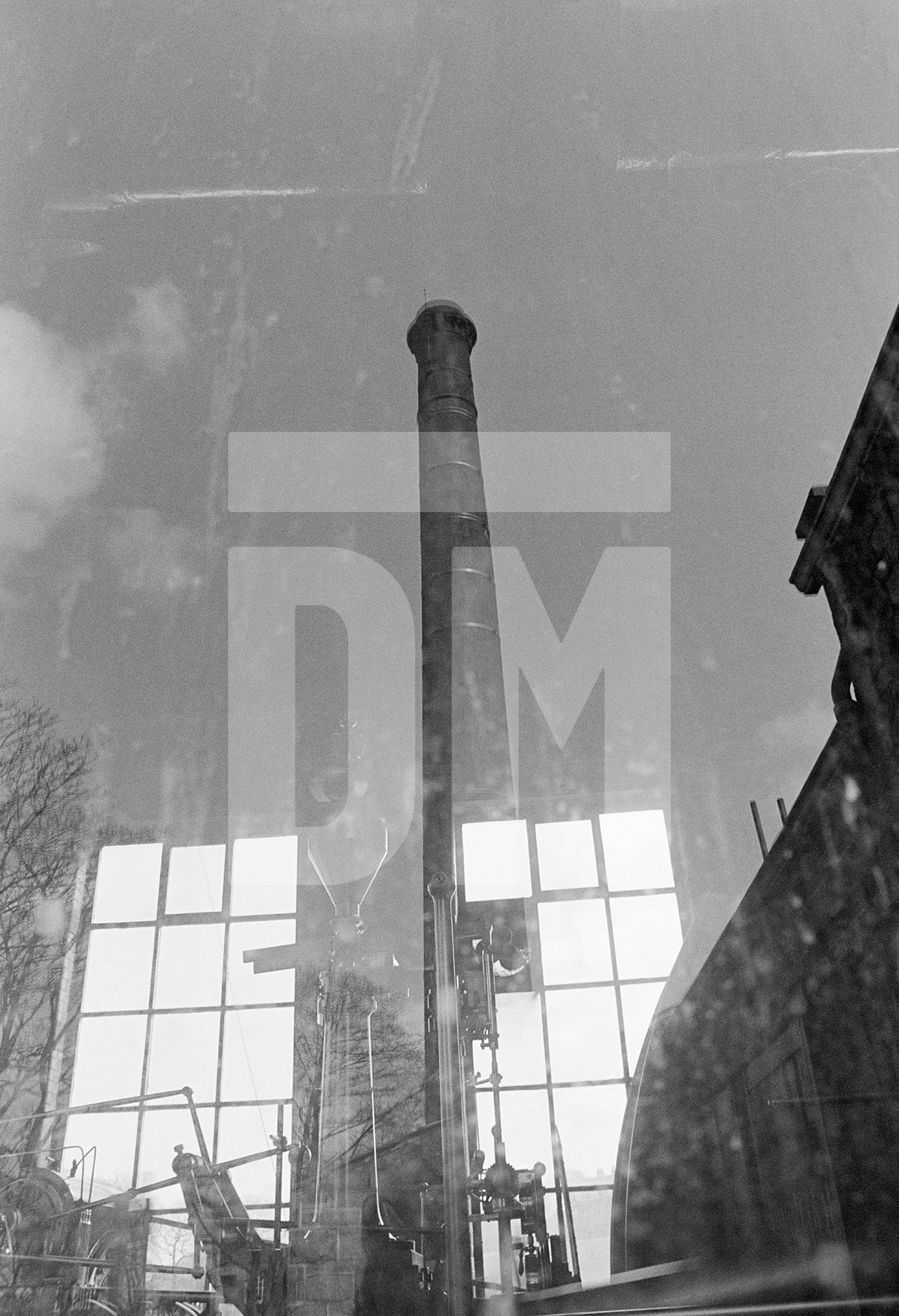 The chimney reflected in a window of the engine house. April 1976 by Daniel Meadows