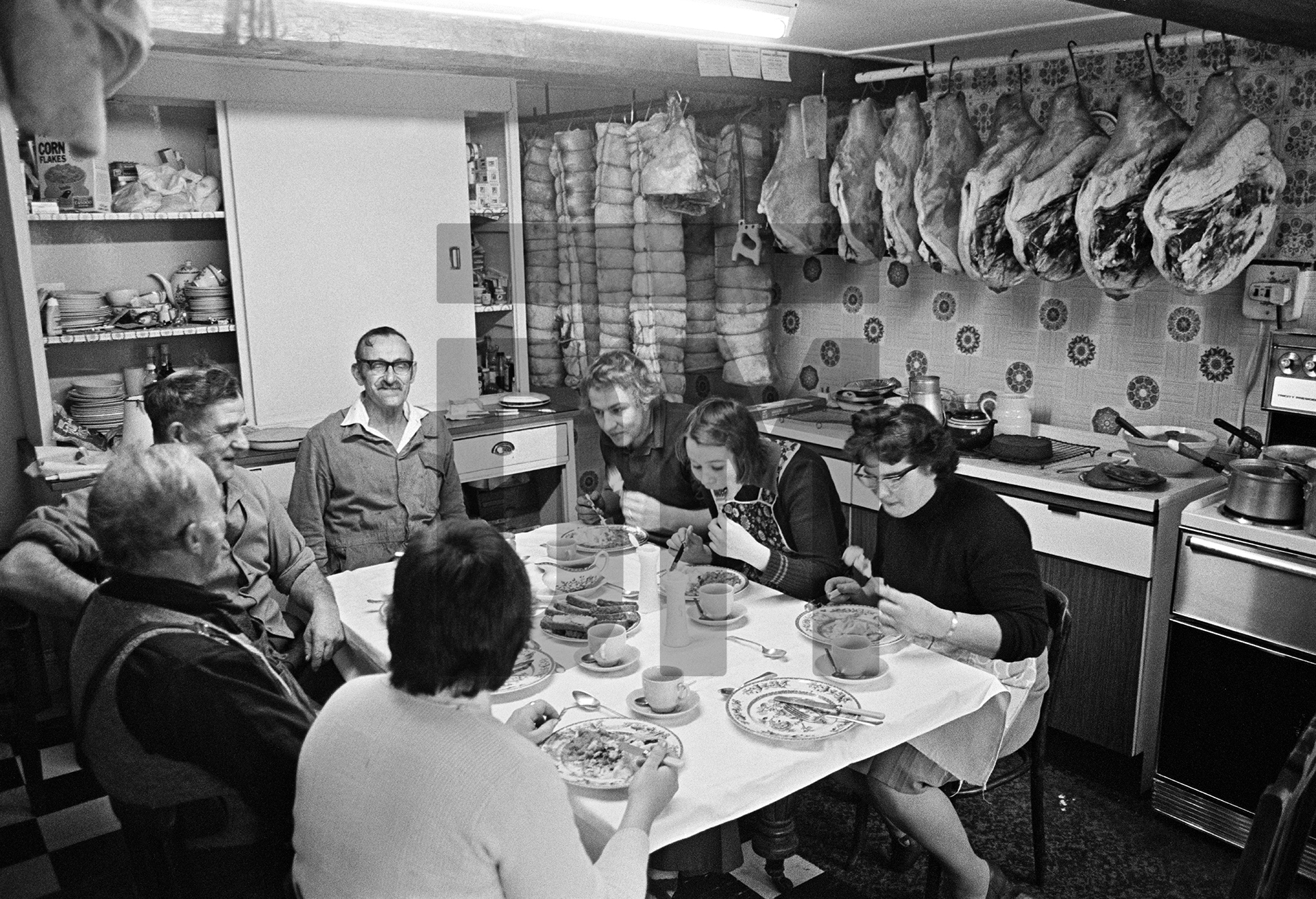 Farmhouse kitchen, lunch break on killing day. Cyril Richardson (arm over back of chair) and family. Old Farm, Little Stainton, near Skipton, North Yorkshire. December 1976 by Daniel Meadows