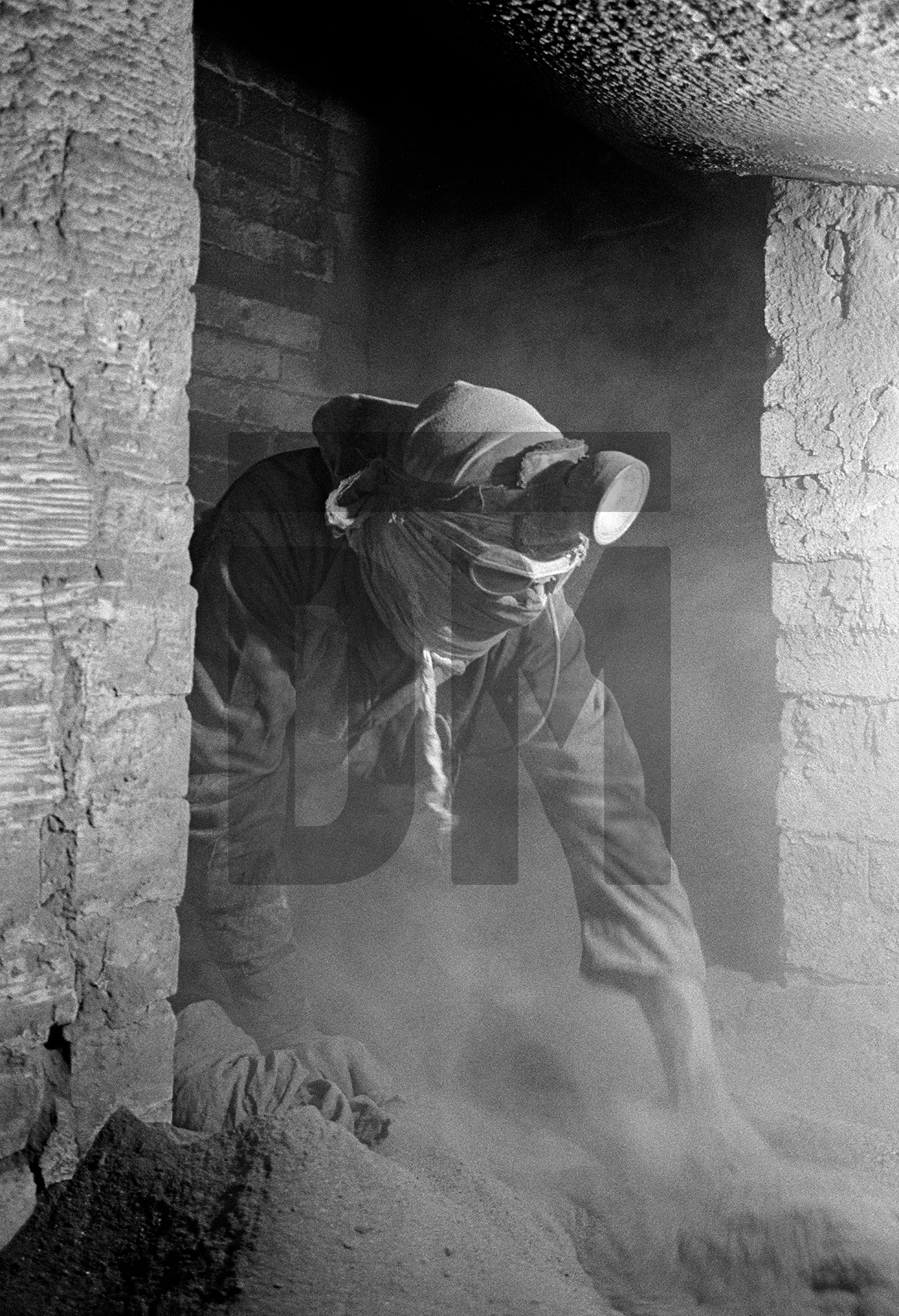 Exiting the side flue beneath the Lancashire boiler, while raking dust. Easter holiday, April 1976 by Daniel Meadows