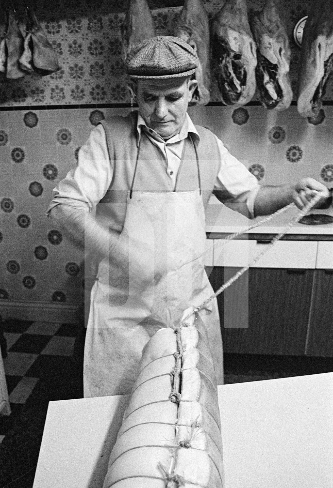 Cyril Richardson knotting twine on a roll of bacon. North Yorkshire 1976 by Daniel Meadows