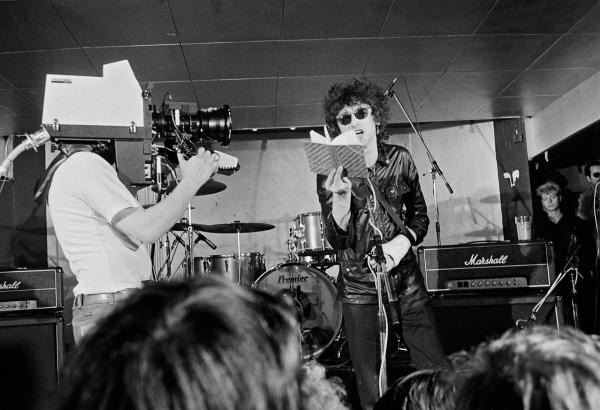 John Cooper Clarke at the Russell Club, Hulme, for a ‘Factory’ night. 'What's On' programme from Granada TV on location. April 1979