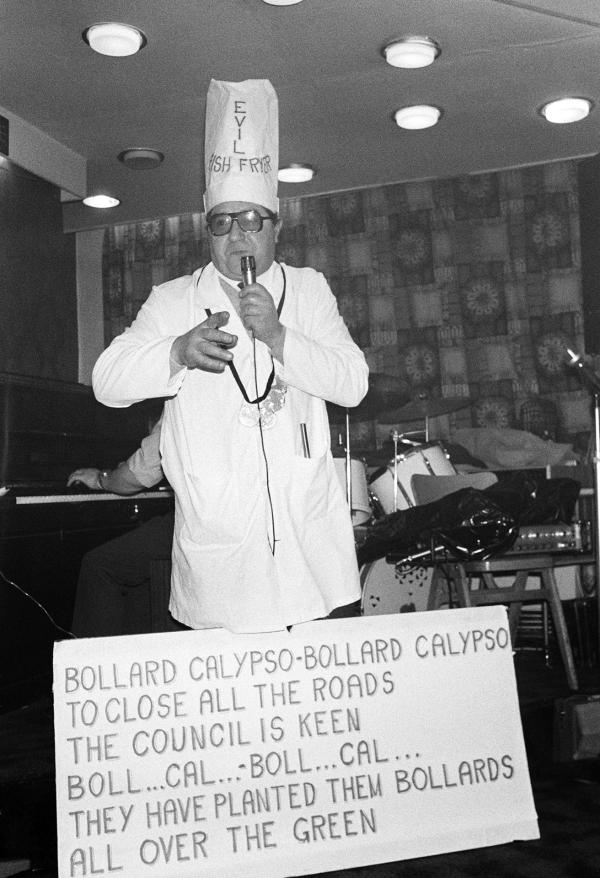 Italo ‘Roy’ Rigali, singing his 'Bollard Calypso' — a protest song against parking restrictions imposed on customers at his fish and chip shop — in a working men's club, Easington Village, Co. Durham. September 1974