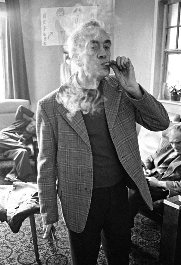 Stanley Massey, aged 57, smokes a ‘toilet roll Havana’, the nickname given to cigarettes made from 'dimps' (fag-ends) with paper ripped from the lining of a cigarette packet or, failing that, a toilet roll. February 1978