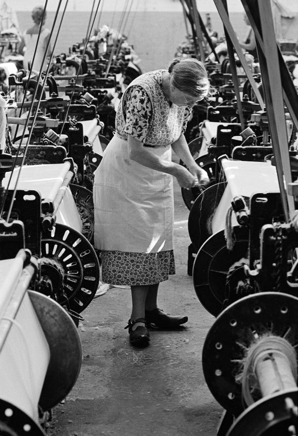 Weaver in ‘brat’ (apron) and clogs, Queen Street Mill, Harle Syke, Burnley, Lancashire. July 1976