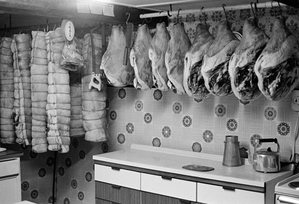 Rolls of bacon and hams hang in the farmhouse kitchen. North Yorkshire 1976