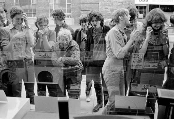 Watching Wimbledon on TVs in an electrical goods shop window. John McEnroe versus Bjorn Borg, tiebreak in the fourth set, Ulverston, Cumbria. 5 July 1980