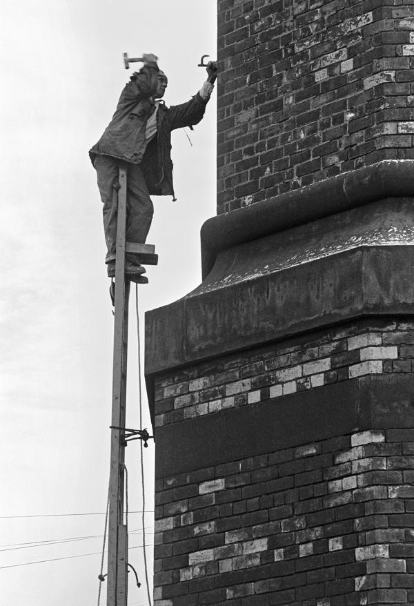 With the first ladder in place, Peter hammers in a ‘dog’ to begin fixing the second ladder. September 1976