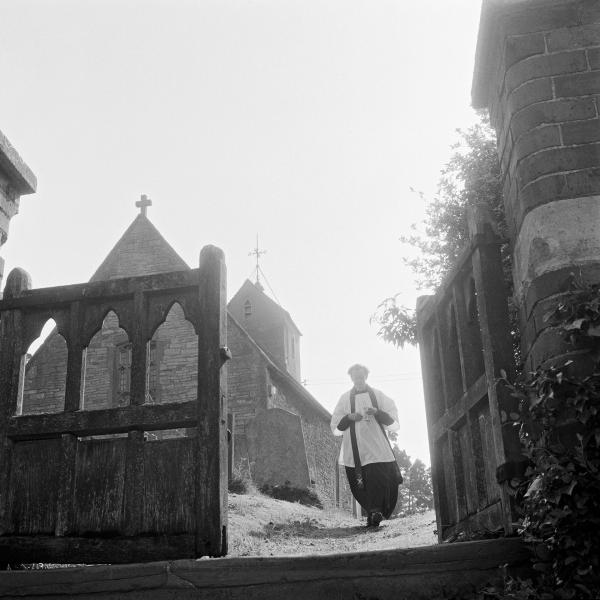 Vicar taking communion to parishoner out in the village during Sunday church service. Great Washbourne, Gloucestershire. July 1974