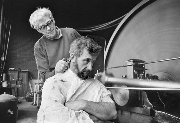 In the engine house. Stanley Graham, mill engineer, having his hair cut. March 1977