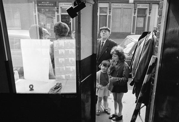 Watching as new pictures are posted in the window of The Shop on Greame Street, Moss Side, Manchester. February-April 1972