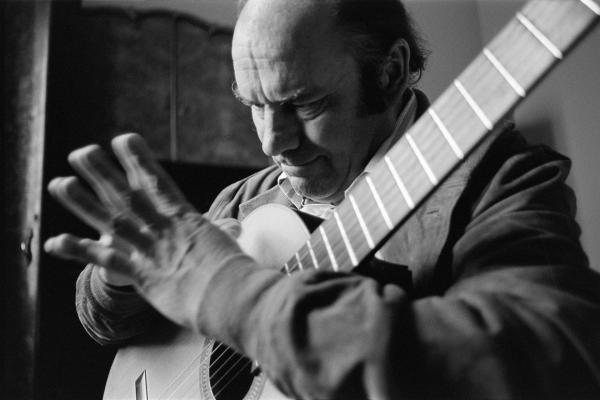 Julian Bream practising guitar in a hotel room while on tour, Italy. March 1981