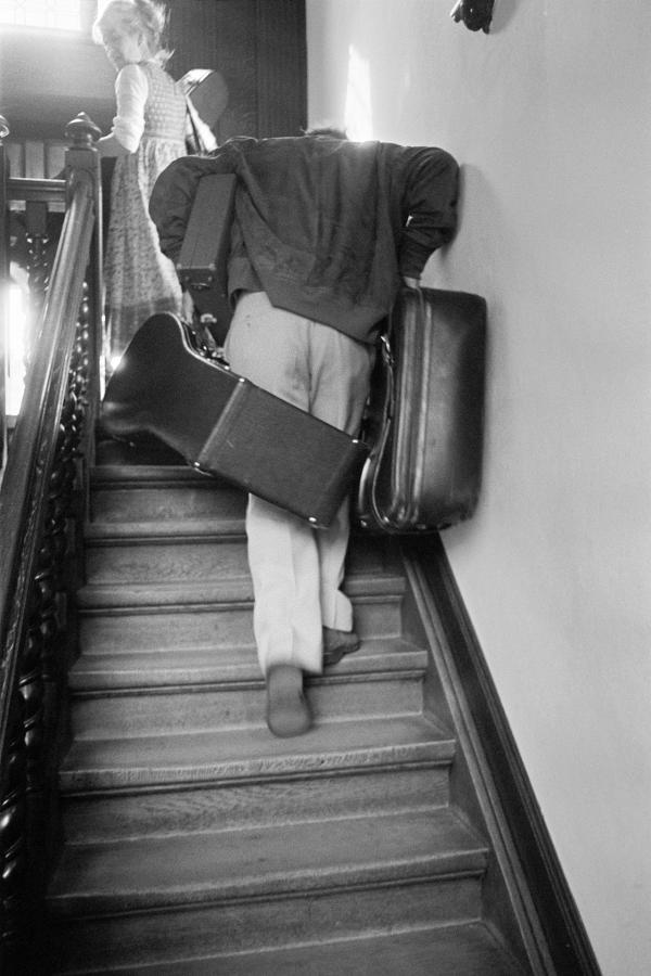 Julian Bream arriving at a hotel, carrying his luggage, Antwerp. September 1981