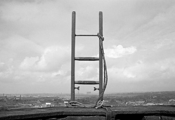 Prior to demolition the laddering is done. Here, 150 feet up, we see the top of the eleventh ladder, complete with lashings. September 1976